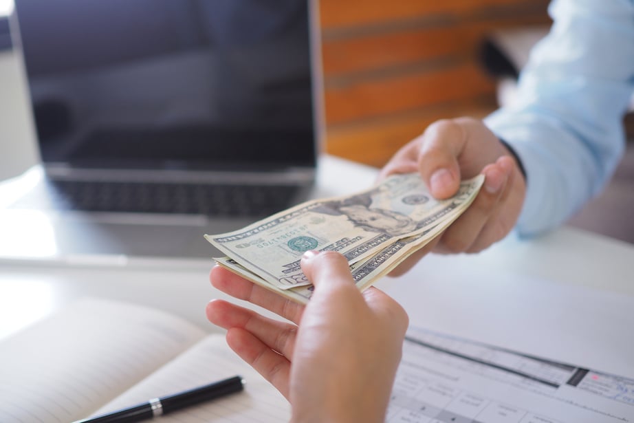 Person Handing Money to Bank Teller